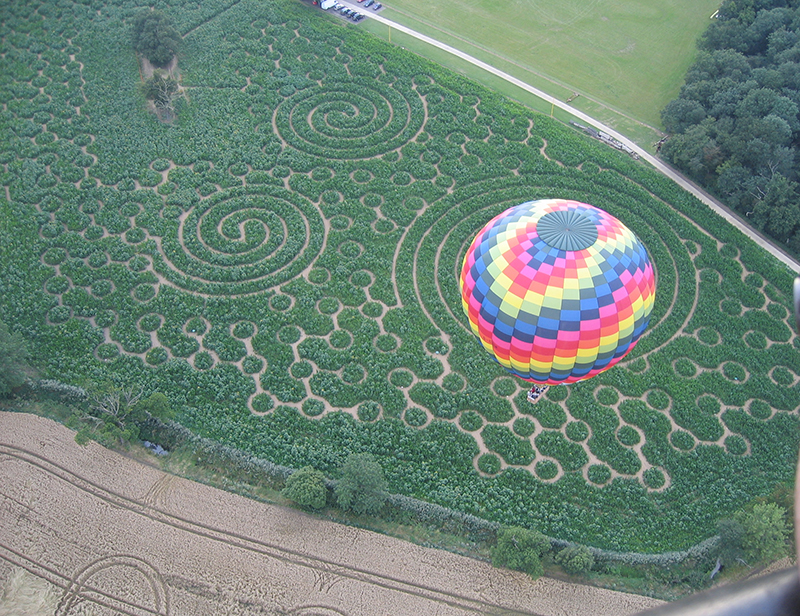 Every year Blake House Craft Centre grows a field of maize and in late summer it is tall enough to be cut to create a maze for visitors to walk in. There have been some great designs over the years and here are just a few that we have snapped on our Essex balloon rides from Blake House over the years.