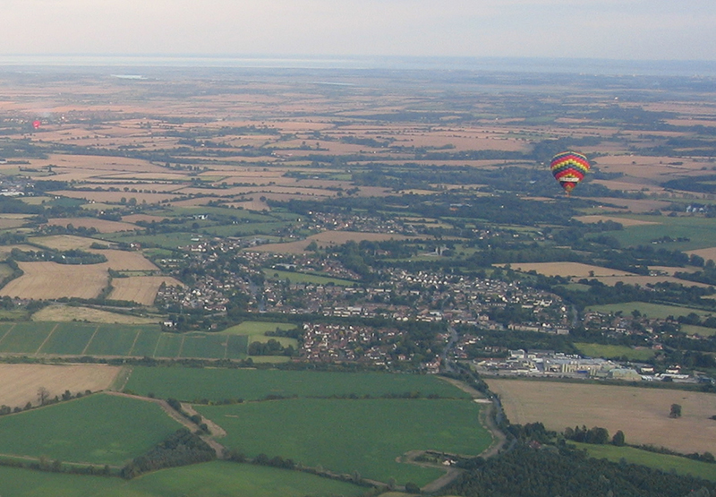 You can take some interesting pictures of the balloon's shadow as it becomes quiet large when you fly at low level on approach to land. This one was taken on a balloon ride over Essex near the A12 dual carriageway near the town of Chelmsford and not far from Hatfield Peverel which is shown in the picture below with the balloon flying over it.