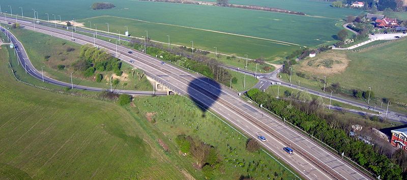 You can take some interesting pictures of the balloon's shadow as it becomes quiet large when you fly at low level on approach to land. This one was taken on a balloon ride over Essex near the A12 dual carriageway near the town of Chelmsford and not far from Hatfield Peverel which is shown in the picture below with the balloon flying over it.