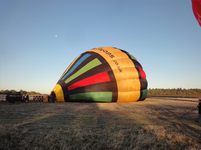 As passengers begin to arrive at a balloon launch site our balloon and crew will have already commenced their preparations of the balloon for flight. They will unload the balloon basket from the balloon trailer, perhaps spread out the 100 foot tall balloon out on the ground, check there is petrol in the fans that will blow cold air into the balloon to ready it for the heat of the burners and that their maps and flight equipment are correct in the basket.